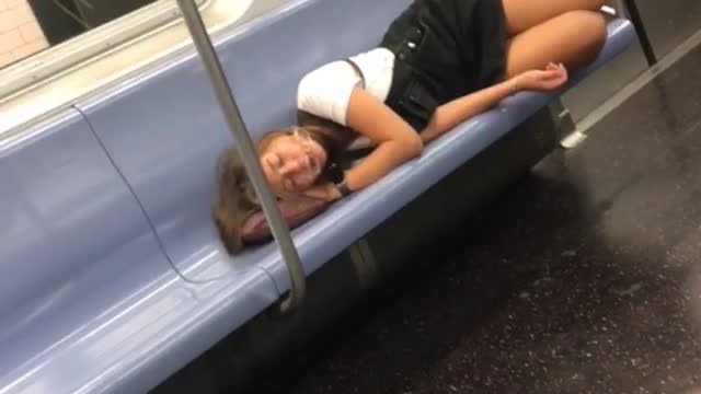 Girl with glasses asleep on her pink purse