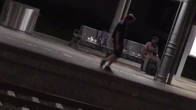 Guy black shorts shirt night time dancing subway platform