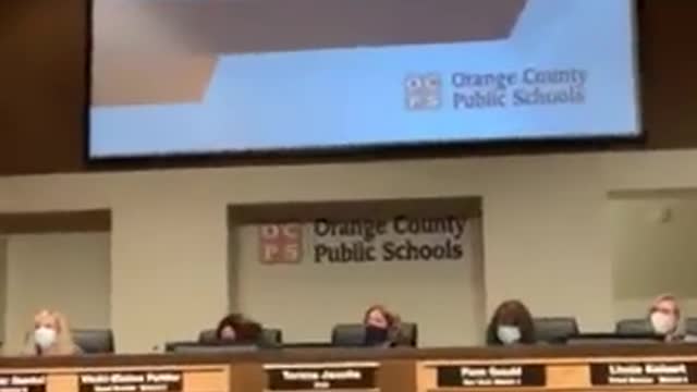 A parent reads a passage from "Gender Queer" at an Orange County, Florida School Board meeting,
