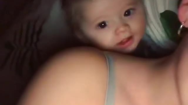 Cute baby laughing with mom on bed !