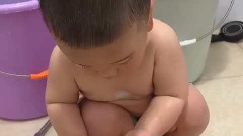 Cute baby bathing with his small hands