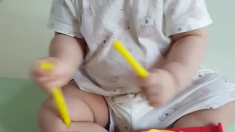 This is a video of a baby playing with a sound book and having fun.