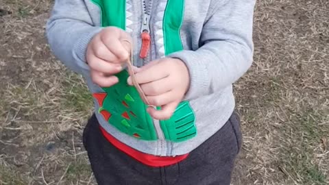 Little Kid Highly Amused by Rubber Band