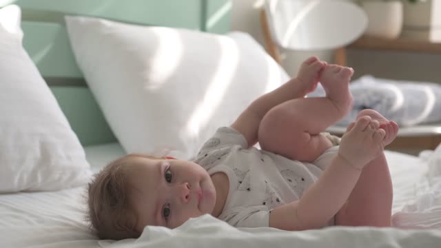 child playing with his feet while he is sleeping