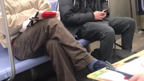 Woman has canvas on her lap and paints man on subway