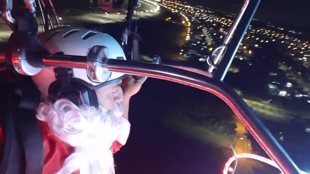 Man Dressed as Santa Flying Over His Hometown