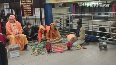 People in orange sitting on subway station floor