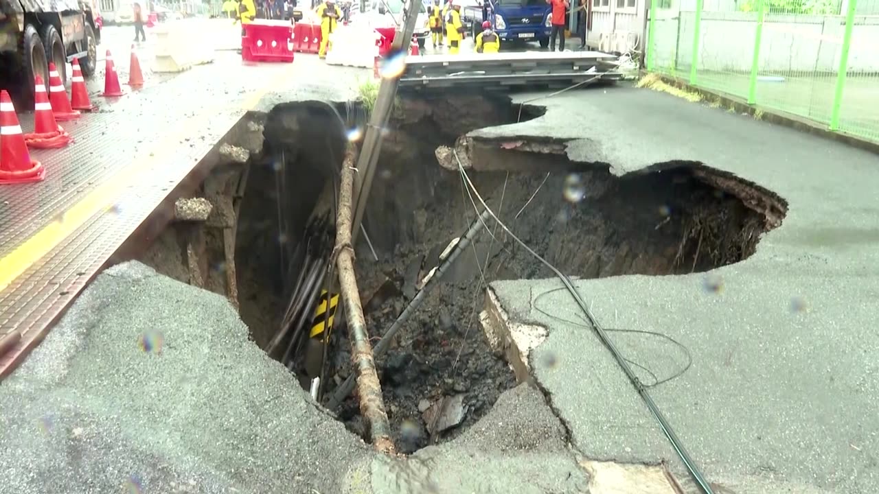 Sinkhole in South Korea swallows two trucks in heavy rain