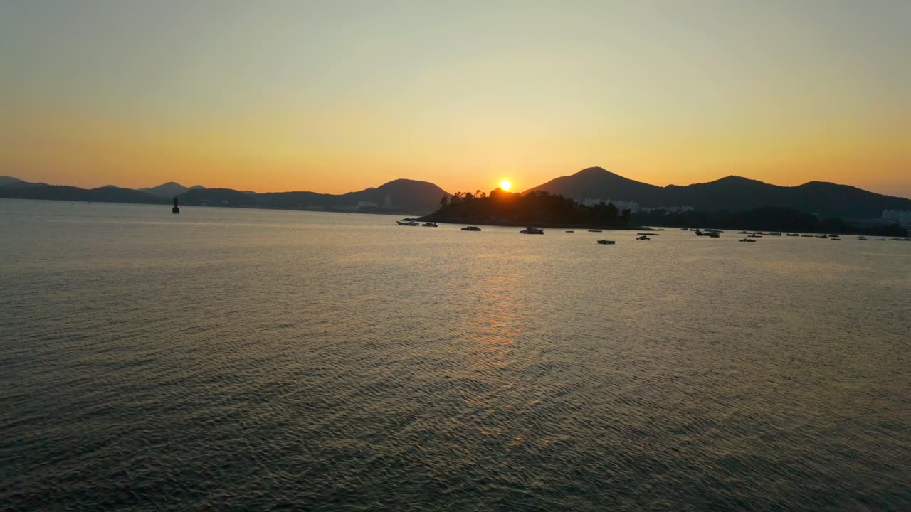 Sunset Over the Sea with a Small Island and Mountain Backdrop in Yeosu