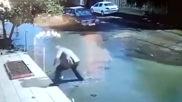 Footage shows a driver rescuing a child from drowning in a giant pothole