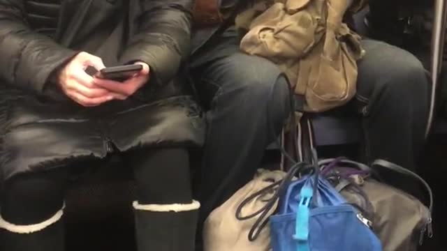 Man plays with four metal balls in hands, has three hats on