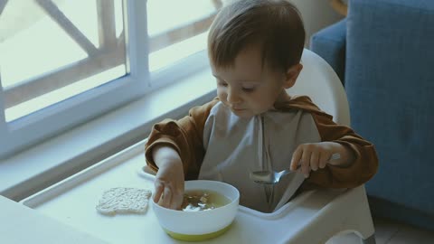 A young child eats by himself