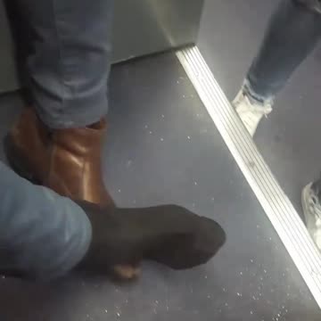 Man brown shoe stuck on hand rest bus
