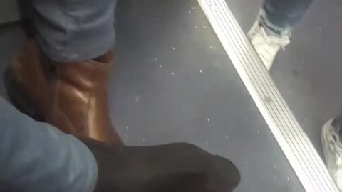 Man brown shoe stuck on hand rest bus