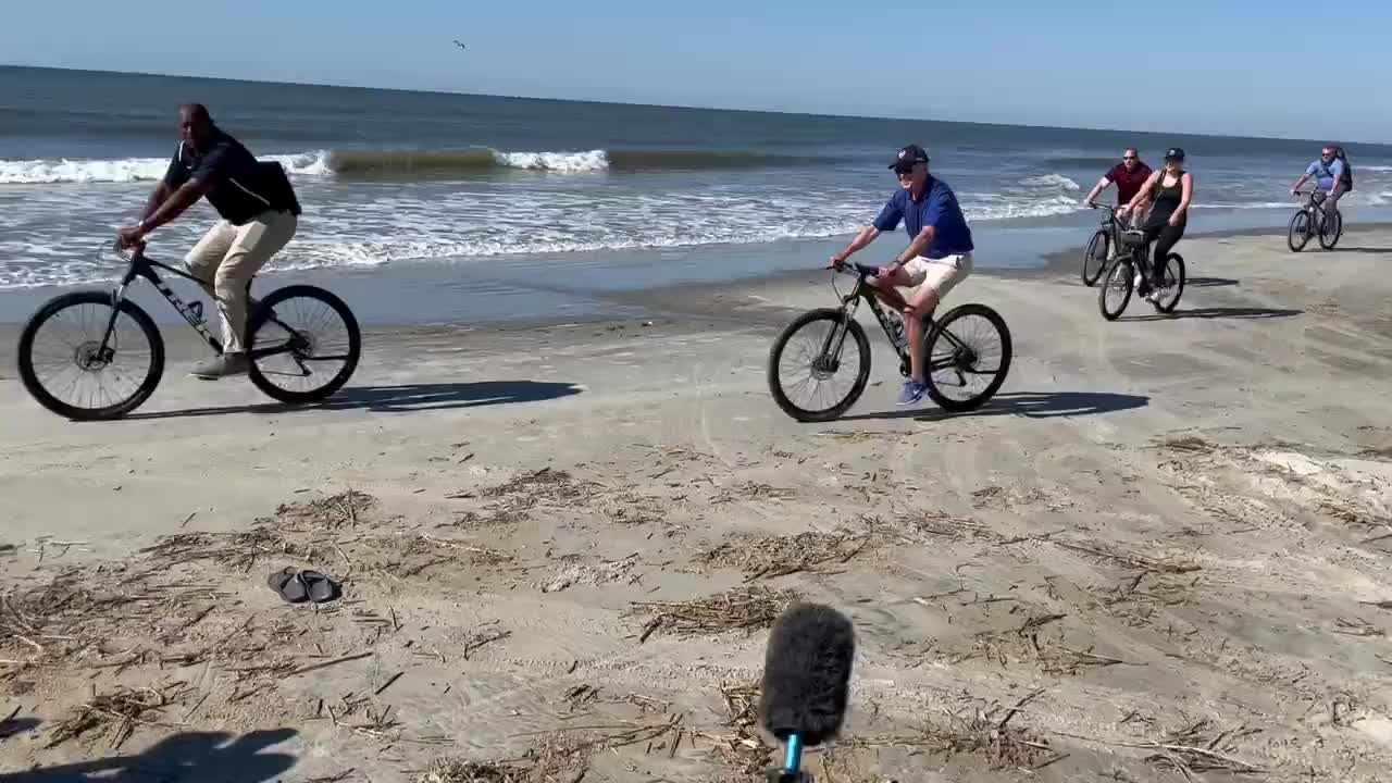 Biden ignores questions from the reporters and goes for a bike ride on the beach in South Carolina.