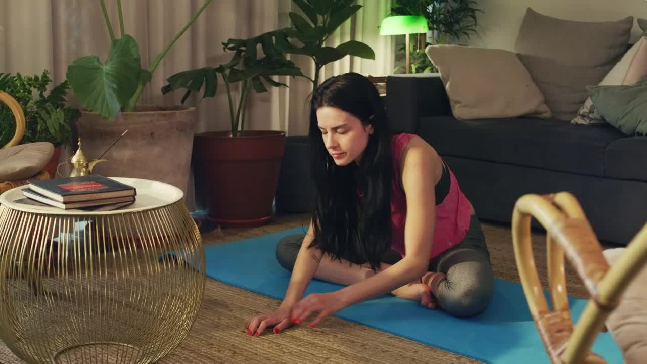 Young woman stretching her body in her living room