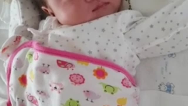 The baby is yawning and stretching