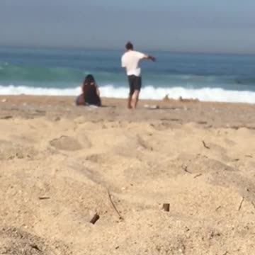 Guy gently dances by himself at the beach