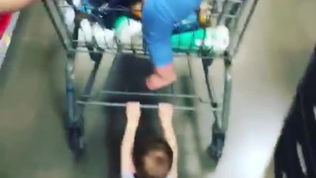 Kid holding onto shopping cart dragged across floor