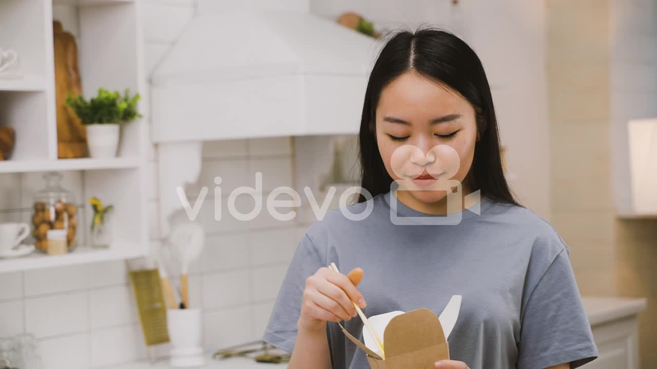 Happy Japanese Girl Eating Takeaway Ramen While Looking At The Camera And Smiling 1