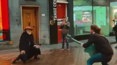 An Old Man dancing to a street musician.