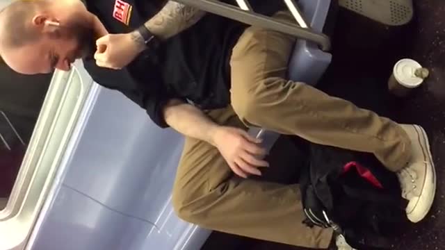 Man playing fake air guitar on train