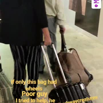 An older man dragging brown suit case