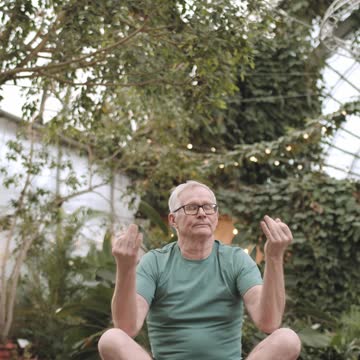 Man Doing Yoga in a Botanical Garden