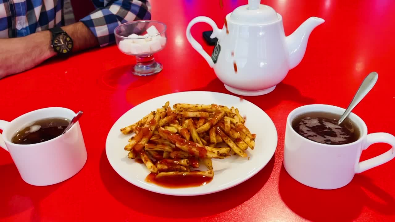 Pouring tomato catchup on fries in slow motion