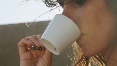 A woman drinking coffee from a mug