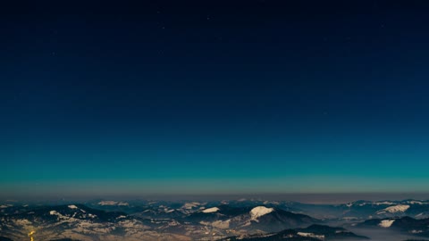 Clear blue sky over winter mountains at dusk