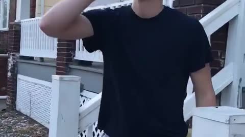 Guy in gray shirt drinking on porch
