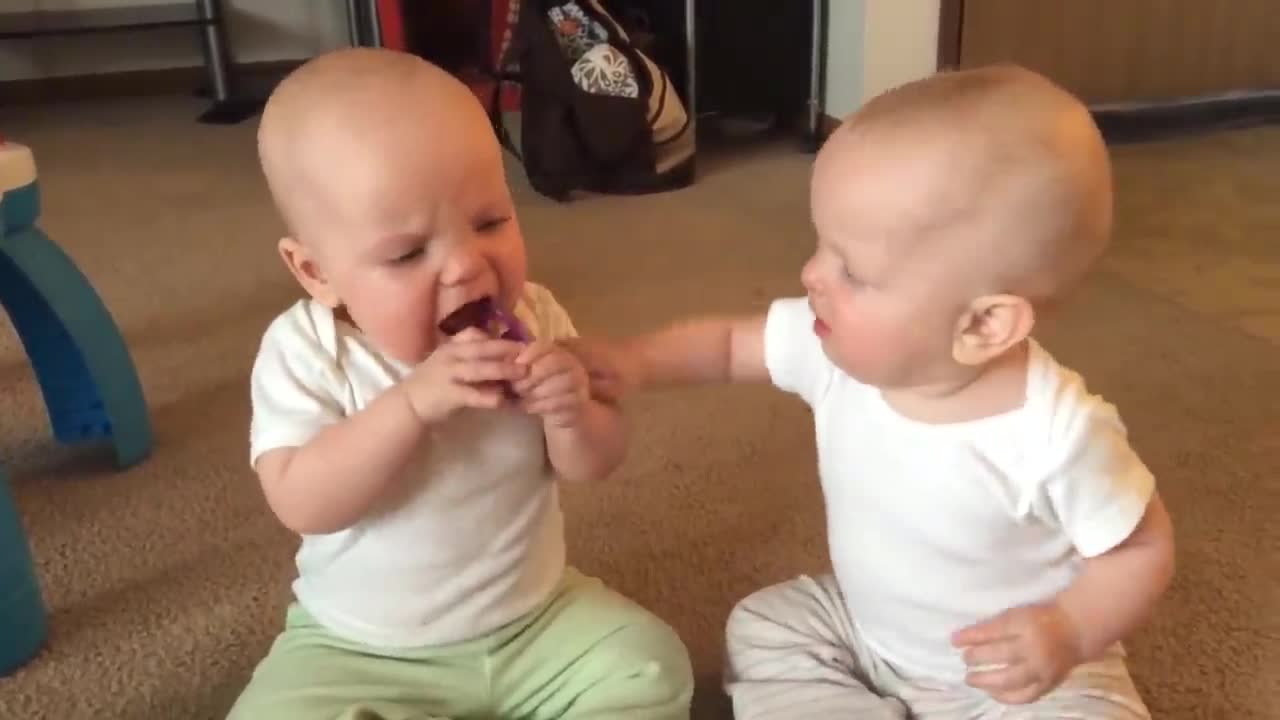 These twin baby girls are so cute fighting over this pacifier!