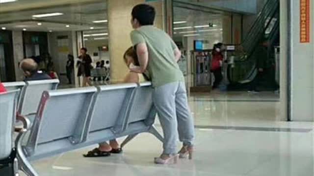 World's best boyfriend? Man wears girlfriend's pink high heels to let her rest her feet.