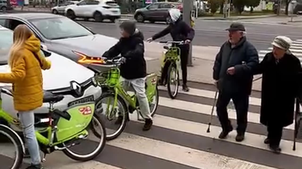 Youngsters on bikes create a roadblock, offering a safe space for the elderly