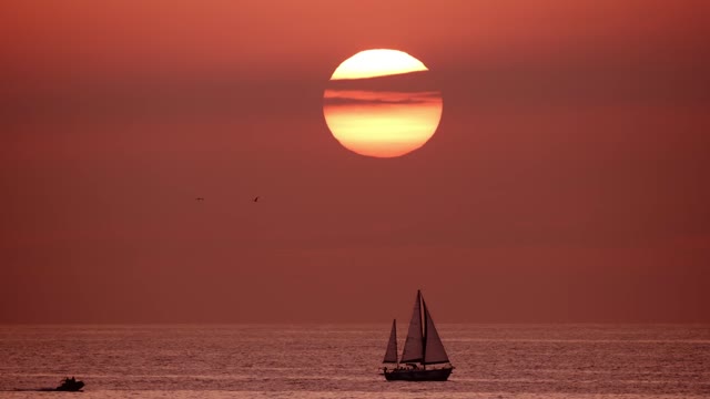 View of the horizon in the sea while a sailboat sails