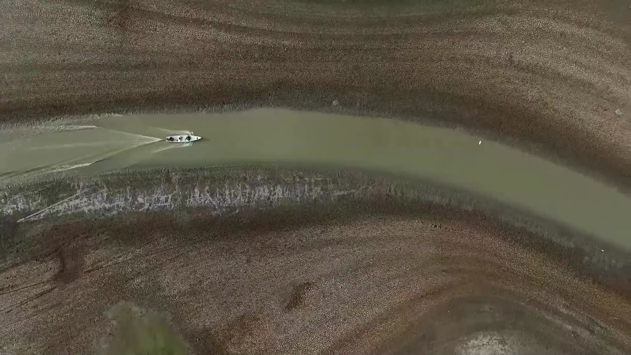 Fishermen drag boats through mud as lake dries up in Brazil