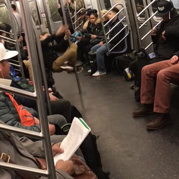 Ponytail guy dances on pole in subway