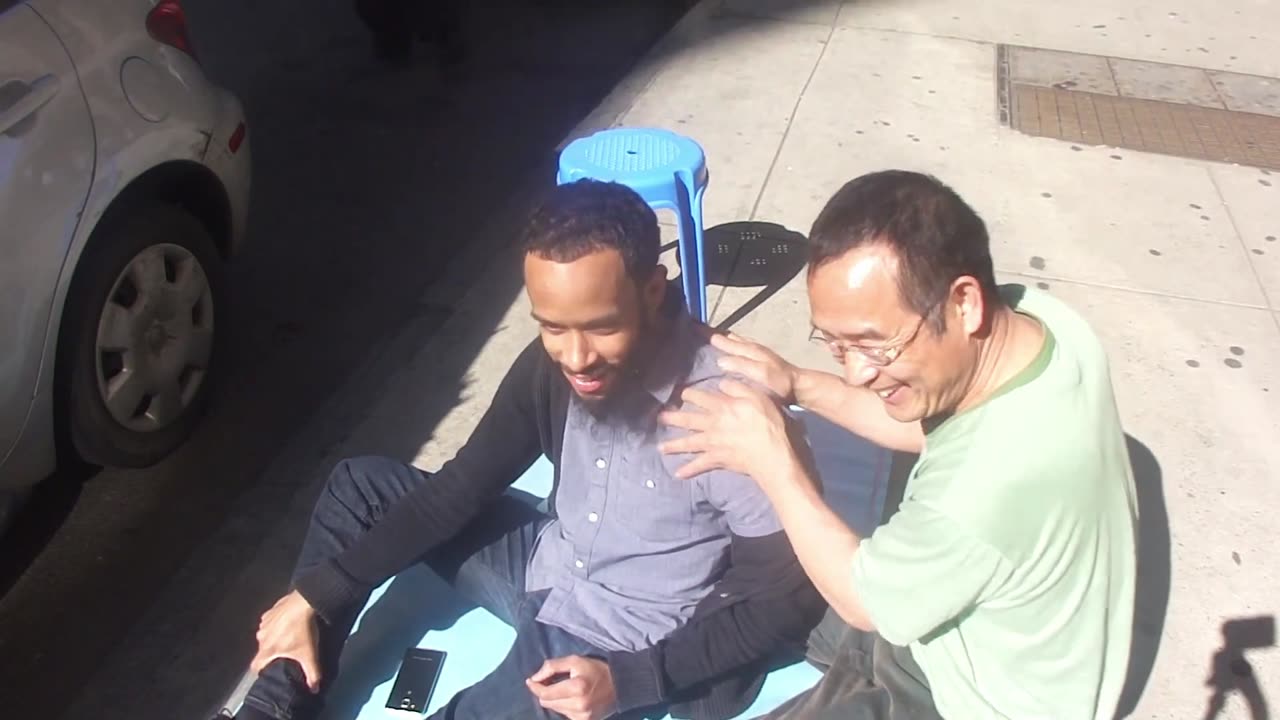 Luodong Massages Skinny Black Man's Shoulder