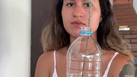 Woman Practices Magic Trick with an Apple and a Bottle