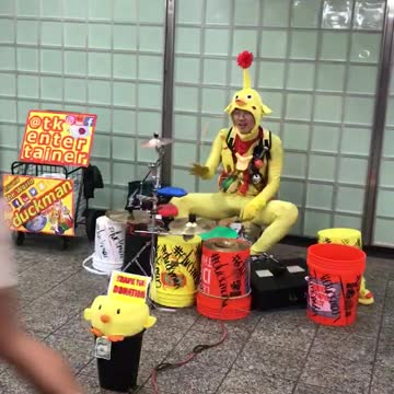 Man in yellow body suite playing drums