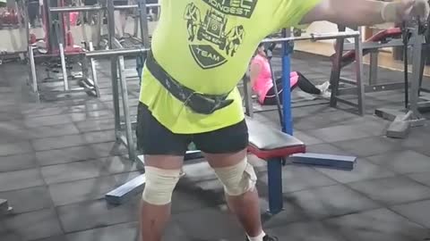 Strong man shakes a dumbbell 100kg