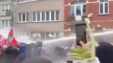 Palestine supporters meet with water cannon from Belgian police.