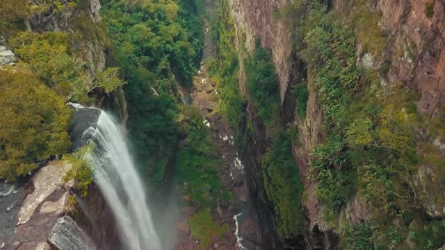 A Waterfalls From High Atop A Mountain To A River