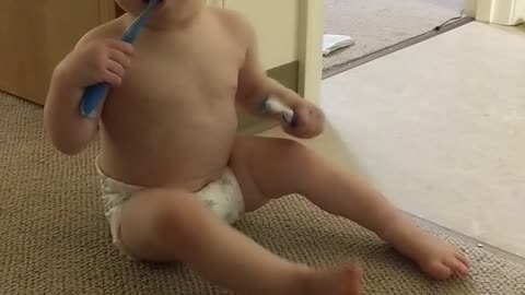 Baby chews on toothbrush and knocks herself over