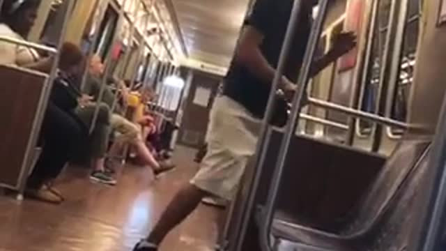 A man in black shirt hat growls like dog on subway