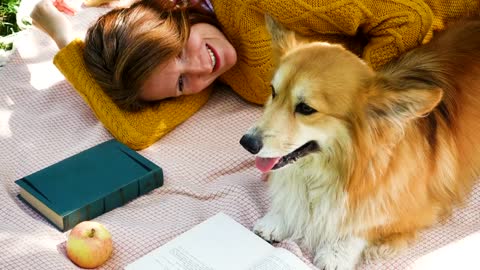 Woman with corgi dog on a picnic day