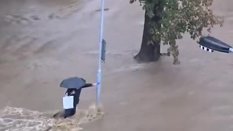 Prąd wody porywa człowieka. Dzisiaj rano. Miasto Jesenik w Czechach. Powyżej