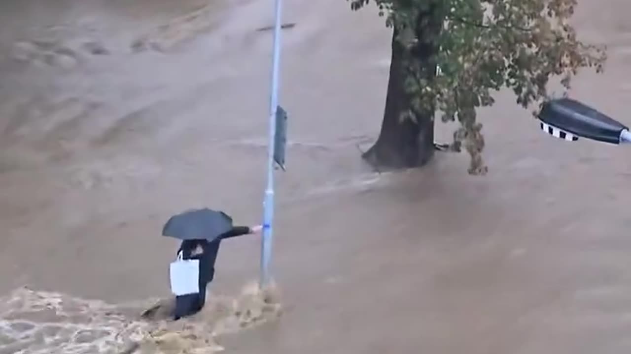 Prąd wody porywa człowieka. Dzisiaj rano. Miasto Jesenik w Czechach. Powyżej