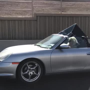 Blonde lady driving with huge tv in passenger seat coupe